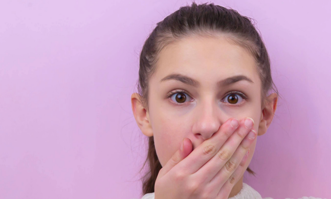 Woman with Hand Across Mouth Covering Up a Toothpaste Allergy