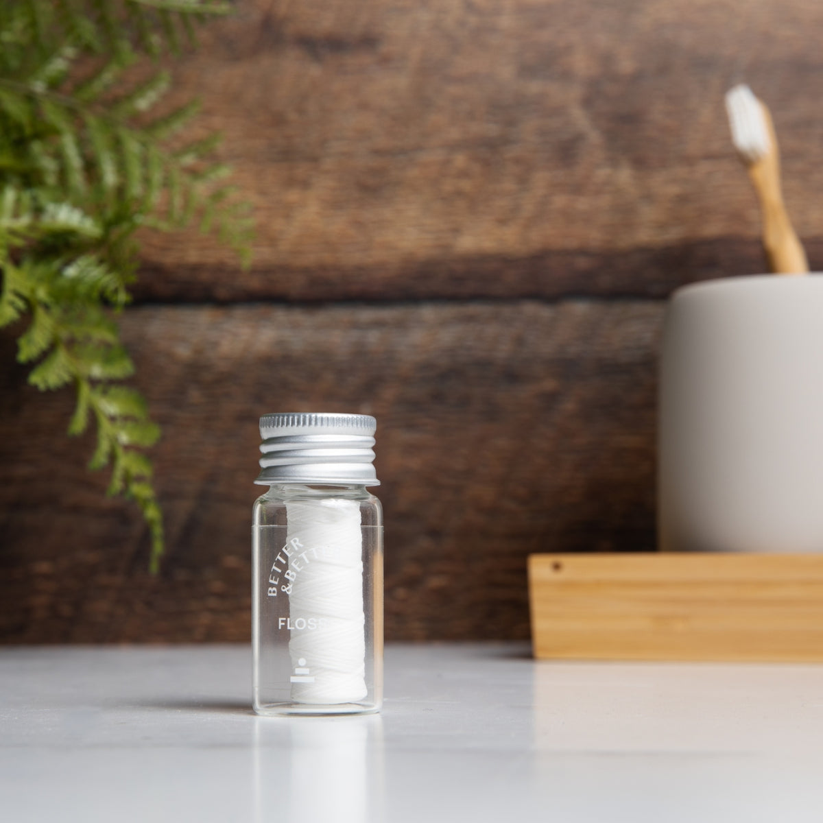 Floss in glass jar on bathroom counter | Vegan, natural floss in refillable glass jar | hover